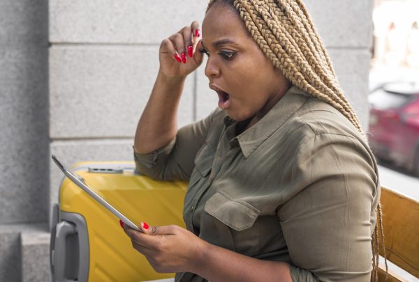 shocked-woman-looking-her-tablet-while-travelling